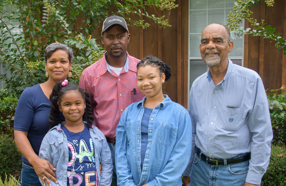 •	A woman, man, and older man stand with two teen girls.