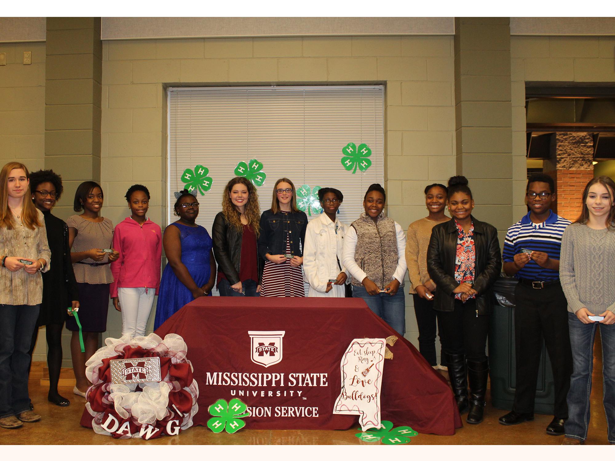 A group of teenagers pose for a photo celebrating their induction as 4-H Leadership team members.