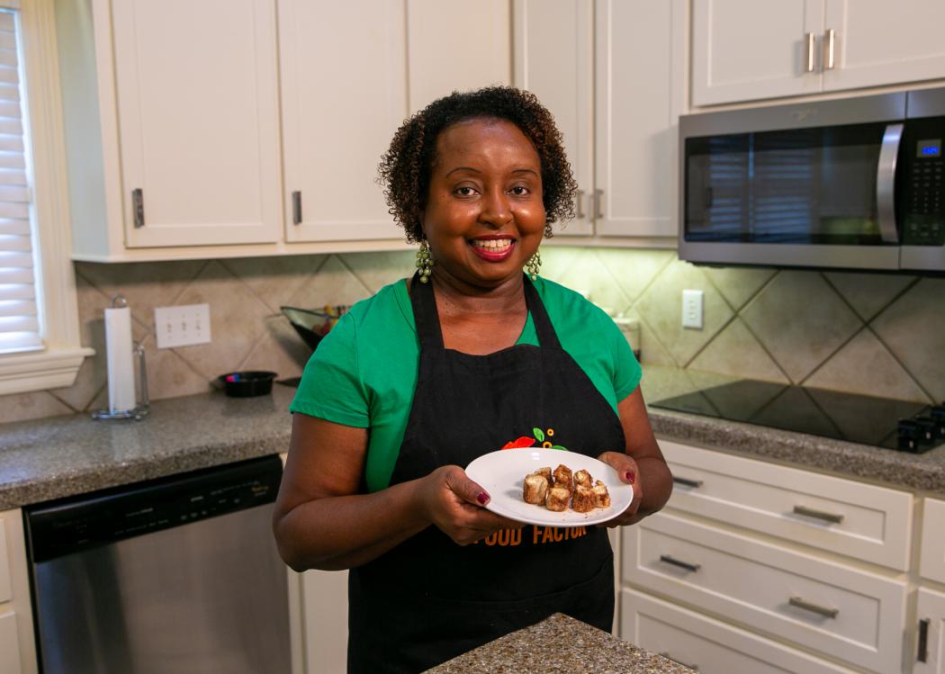 A woman in a kitchen holds a plate of Cinnamon Swirls.