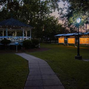 Lights shining at a gazebo and an art display.