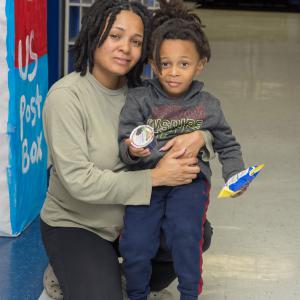 A mother embraces her son in a school hallway.