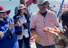 Man showing fish to group