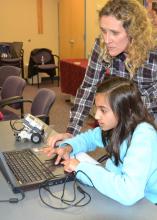 Khadeeja Baig enters information into the computer that will program her robot to turn in a circle as children’s librarian Becky Bowen looks on. Baig is one of 15 children enrolled in the second session of a six-week robotics course at the Rebecca Baine Rigby Library in Madison. (Photo by MSU Extension Service/Susan Collins-Smith)