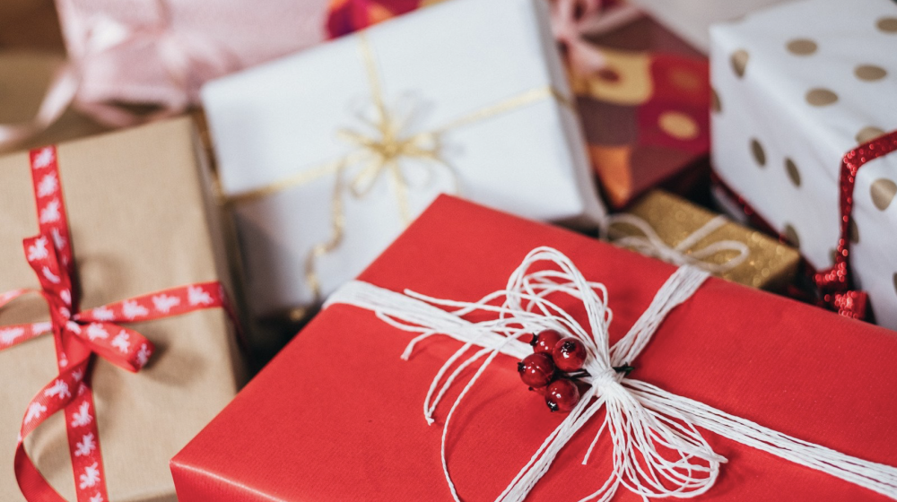 A pile of gifts wrapped in various papers and ribbons.