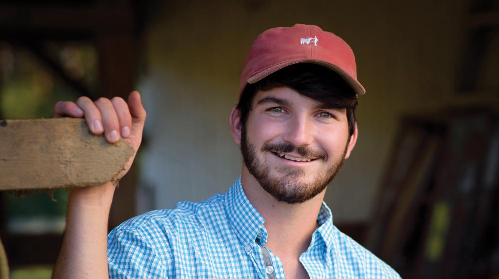 A young man wearing a cap and checked shirt.