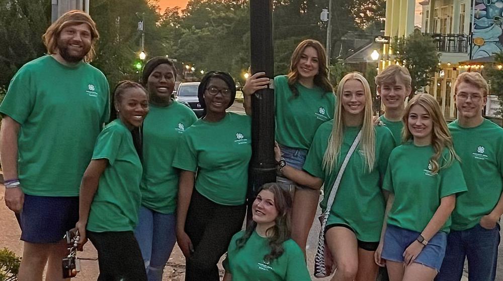 Group of 4-H congress participants posing for a pictures by a street lamp post