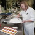 Lorrie Bryan, cake decorator at the Mississippi State University Fountain Bakery, creates Bully's pawprints to cupcakes after whipping up a batch of maroon frosting. (Photo by Scott Corey)