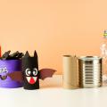 Homemade pumpkin, bat, monster Halloween decor with a toilet paper roll, tin can, and water bottle.