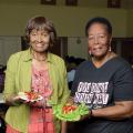 Two elderly women display their healthy food choices.