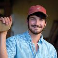 A young man wearing a cap and checked shirt.