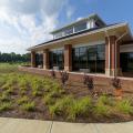 Grasses and small bushes adorn a landscape bed in front of a building.