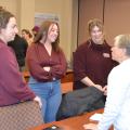 Four people in a small group talk.