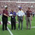 Mississippi State University Extension director Gary Jackson took to the field Sept. 7, 2013, at the MSU home opener to present a commemorative football to visiting Alcorn State University partners. From left are Jackson; Alcorn Extension administrators Dalton McAfee and Anthony Reed; and Gregory Bohach, MSU vice president for the Division of Agriculture, Forestry and Veterinary Medicine. (Photo by MSU Ag Communications/Kat Lawrence)