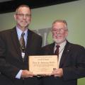 Jeff Parrett, currently of Wheeler Lumber and past president of the Railway Tie Association, left, presents Terry Amburgey, Mississippi State University professor emeritus and Giles Distinguished Professor, with the association's lifetime merit award. (Photo by Gary Coleman/Coleman Photography)